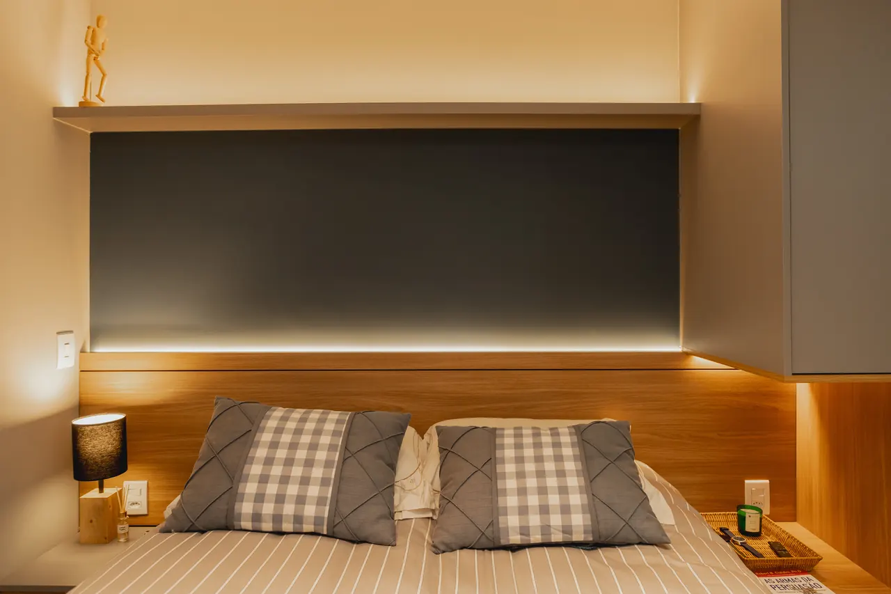 Quarto com cabeceira em madeira, painel com fita de LED e criados-mudos embutidos