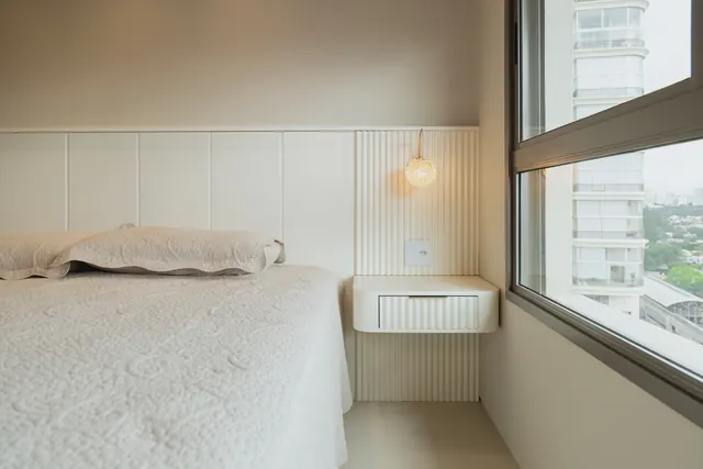 Quarto com cabeceira em ripado claro e criado-mudo flutuante