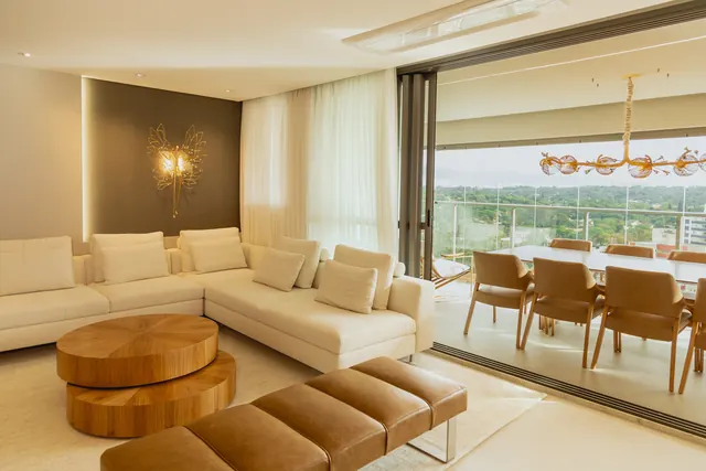 Living integrado à varanda, com painel sob medida e mesa de jantar ao fundo